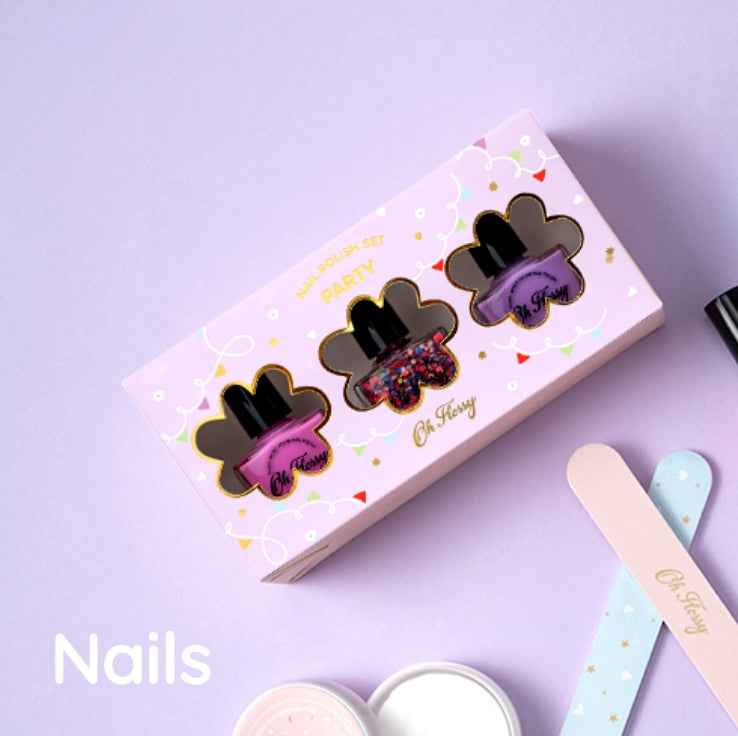 A pink nail polish set box labeled 'PARTY' with three nail polish bottles visible through cutout windows - in pink, confetti and purple colours - styled on a lavender background with nail files and nail polish remover and the text 'Nails' at the bottom left.